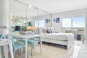 A hotel room with a bed, a desk with chairs, a TV, and a balcony with a view. - Vista Mar, Minutes to Beach, Cozy (North Bay Village)