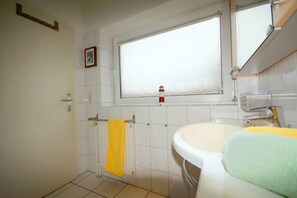 Bathroom with a sink, window, and towel.