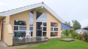 A single-story house with a large front porch, a covered patio, and a grassy yard.