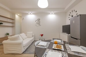 Un salon moderne avec un canapé, une table à manger et un téléviseur.