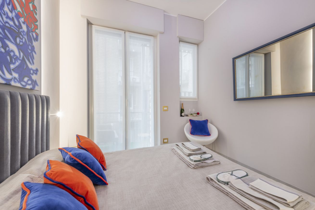 Une chambre d’hôtel avec un lit, une fenêtre, des toilettes et un miroir.