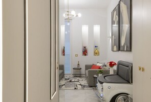 Een moderne woonkamer met een oldtimer, een bank, een salontafel en een kroonluchter.