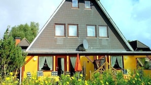 Una casa con techo inclinado, varias ventanas y una antena parabólica.