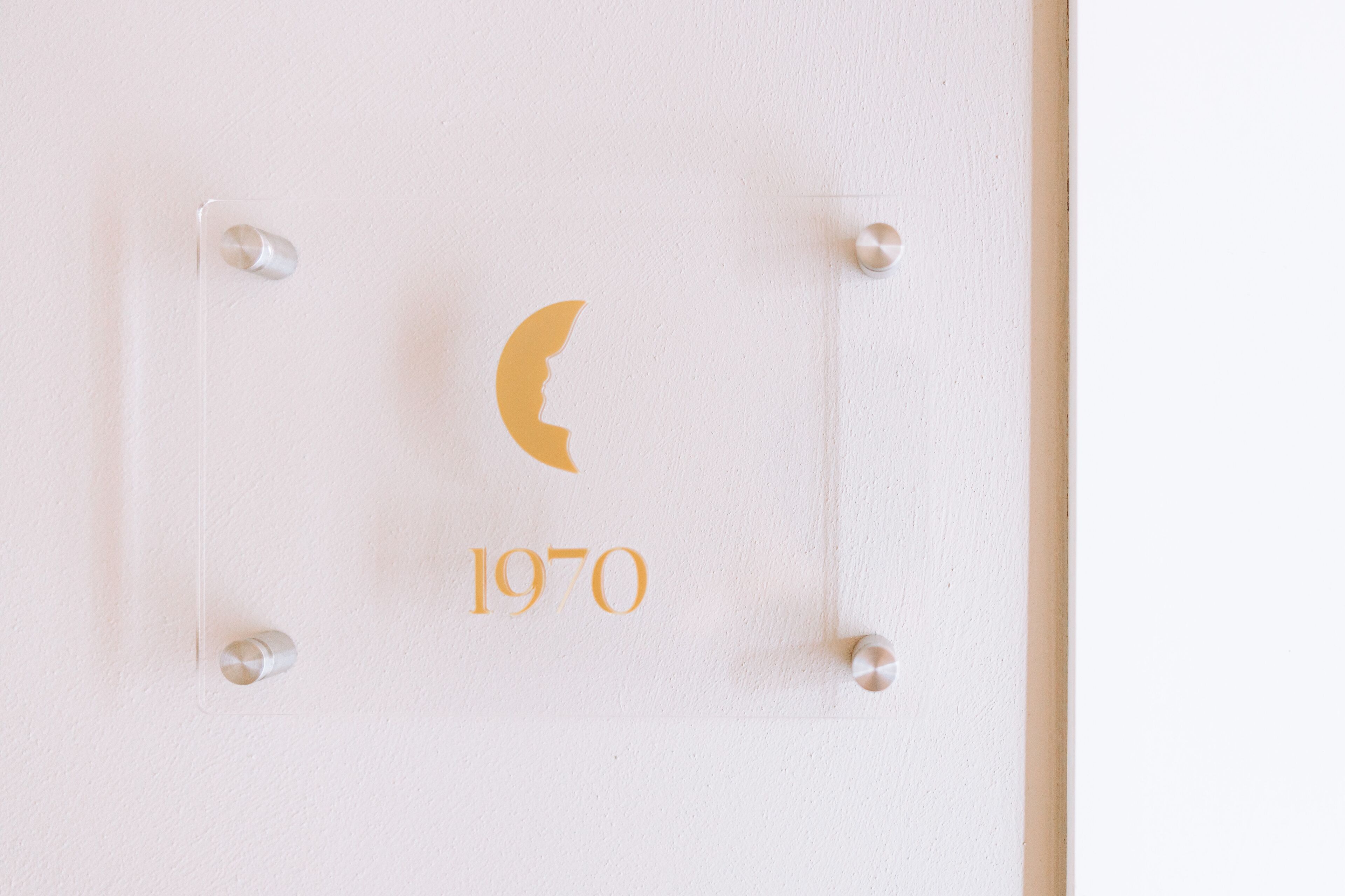 A wall-mounted plaque with a crescent moon and the year '1970' in gold lettering.