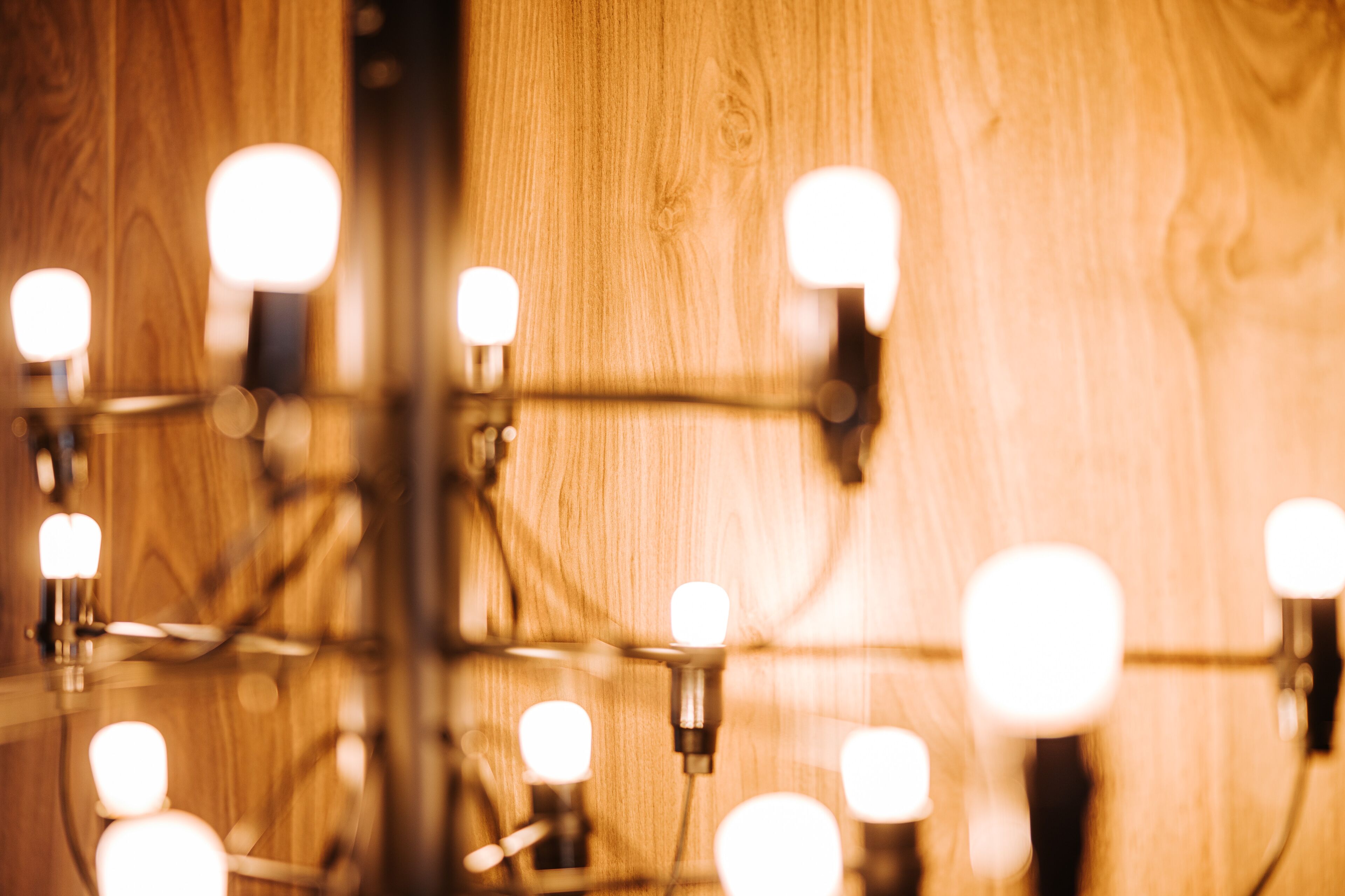 Un gros plan d’un mur en bois orné de plusieurs luminaires.