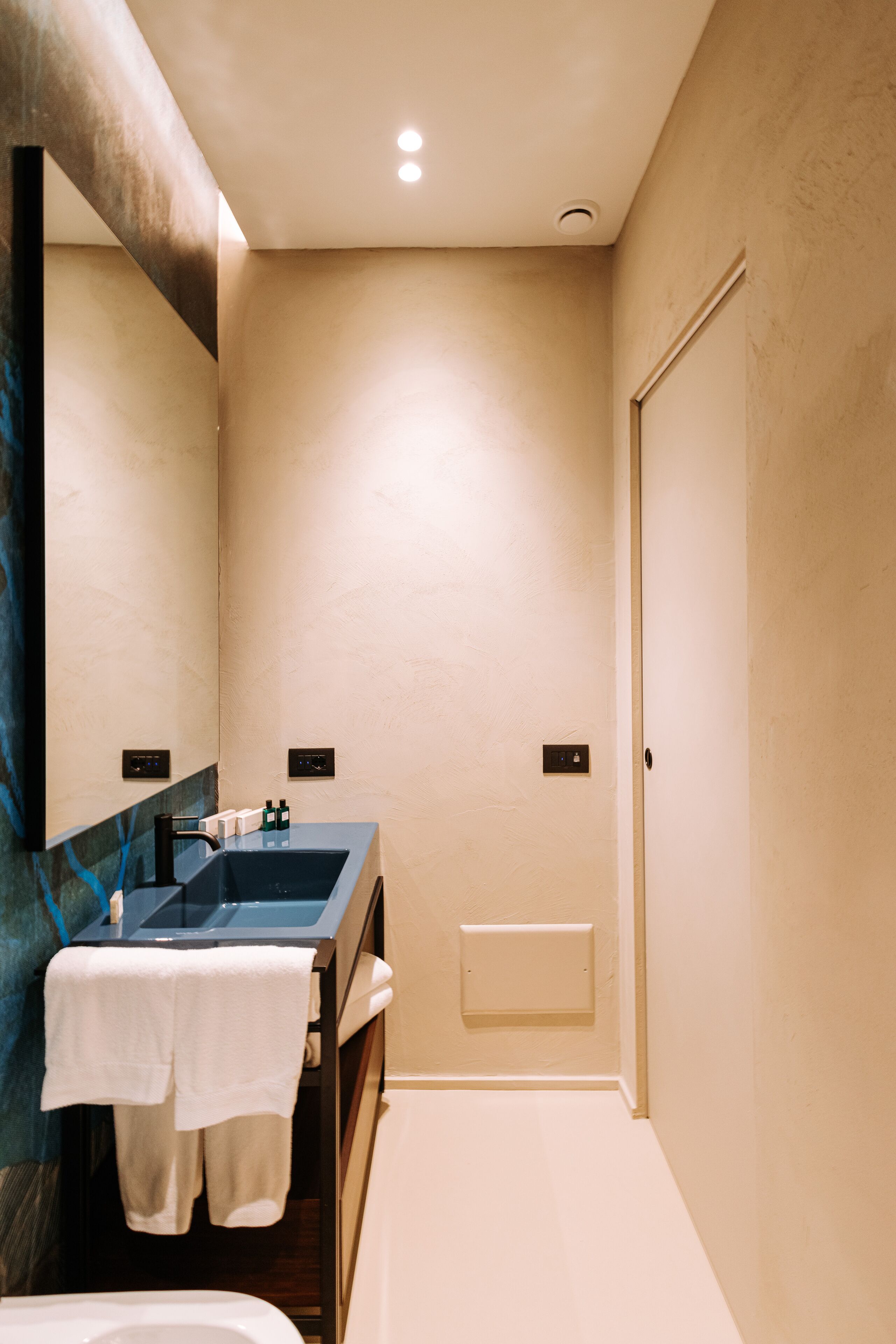 Un bagno moderno con uno specchio grande, un lavandino e una vasca da bagno.