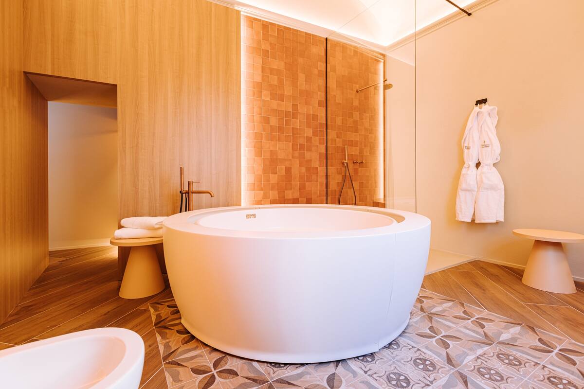 A modern bathroom with a freestanding bathtub, a toilet, and a sink.
