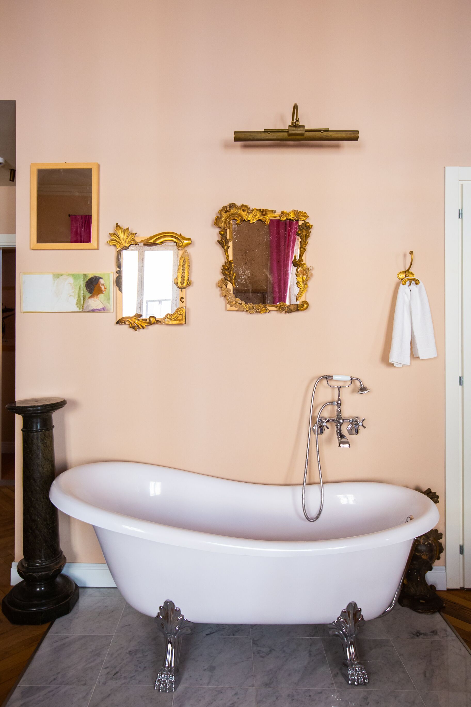 A bathroom with a freestanding bathtub, a vanity with a mirror, and a towel rack.