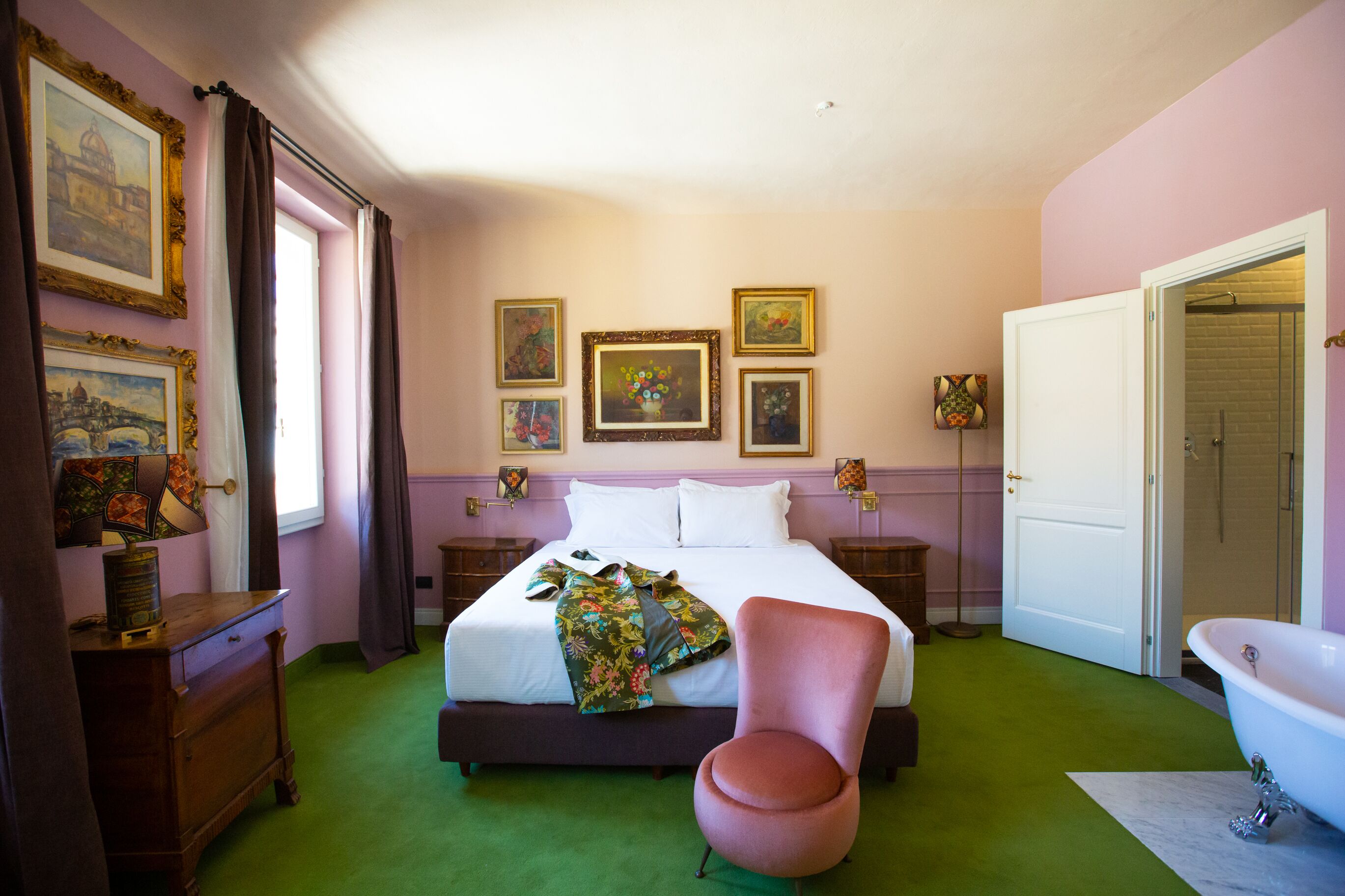 Un dormitorio con cama, una silla, cómoda, tocador y baño con bañera.