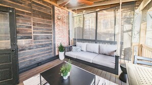 Un interior de madera con un sofá, una mesa de centro con una planta y un ventilador de techo.