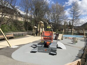 A playground with climbing structures, a slide, and a sandbox.