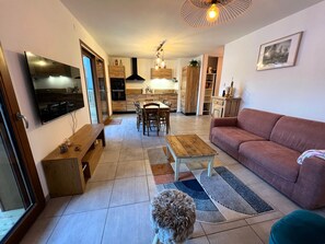 A living room with a sofa, a coffee table, and a TV. There's a dog in the room.