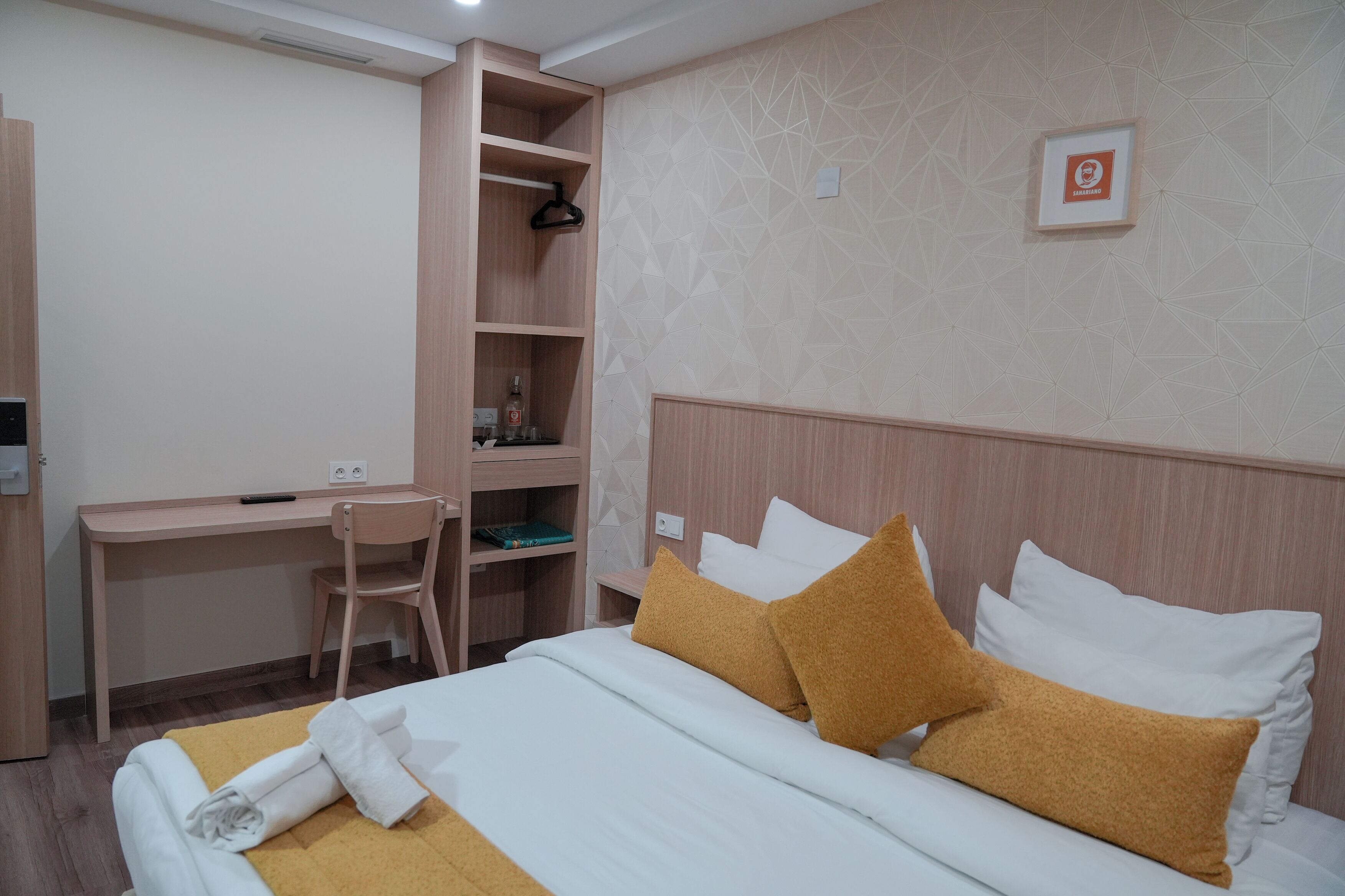 Una habitación de hotel con una cama, un escritorio y una silla.