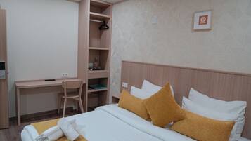 Una habitación de hotel con una cama, un escritorio y una silla.