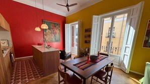 Un comedor con una mesa de madera, sillas y una pared roja.