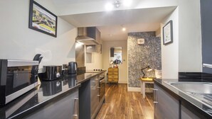 A modern kitchen with a central island, stainless steel appliances, and wooden flooring. - York One Bedroom Apartment with outdoor area (York)