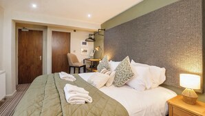 A hotel room with a large bed, a desk, a chair, and a lamp. - York One Bedroom Apartment with outdoor area (York)