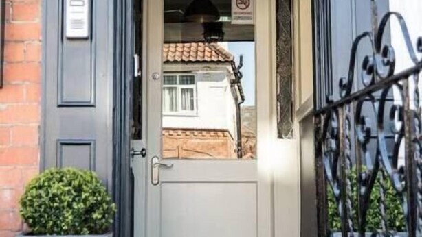 A building entrance with a door, a small potted plant, and a metal gate. - York One Bedroom Apartment with outdoor area (York)