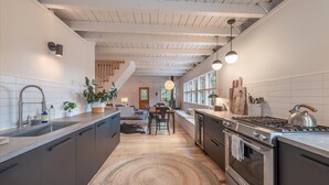 A modern kitchen with a central island, built-in appliances, and a view to the dining area. - Modern cabin retreat! Cozy, scenic, and serene! (Carnelian Bay)