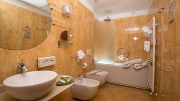 Een moderne badkamer met een grote wastafel, een bidet, toilet en een douchecabine met glazen wanden.