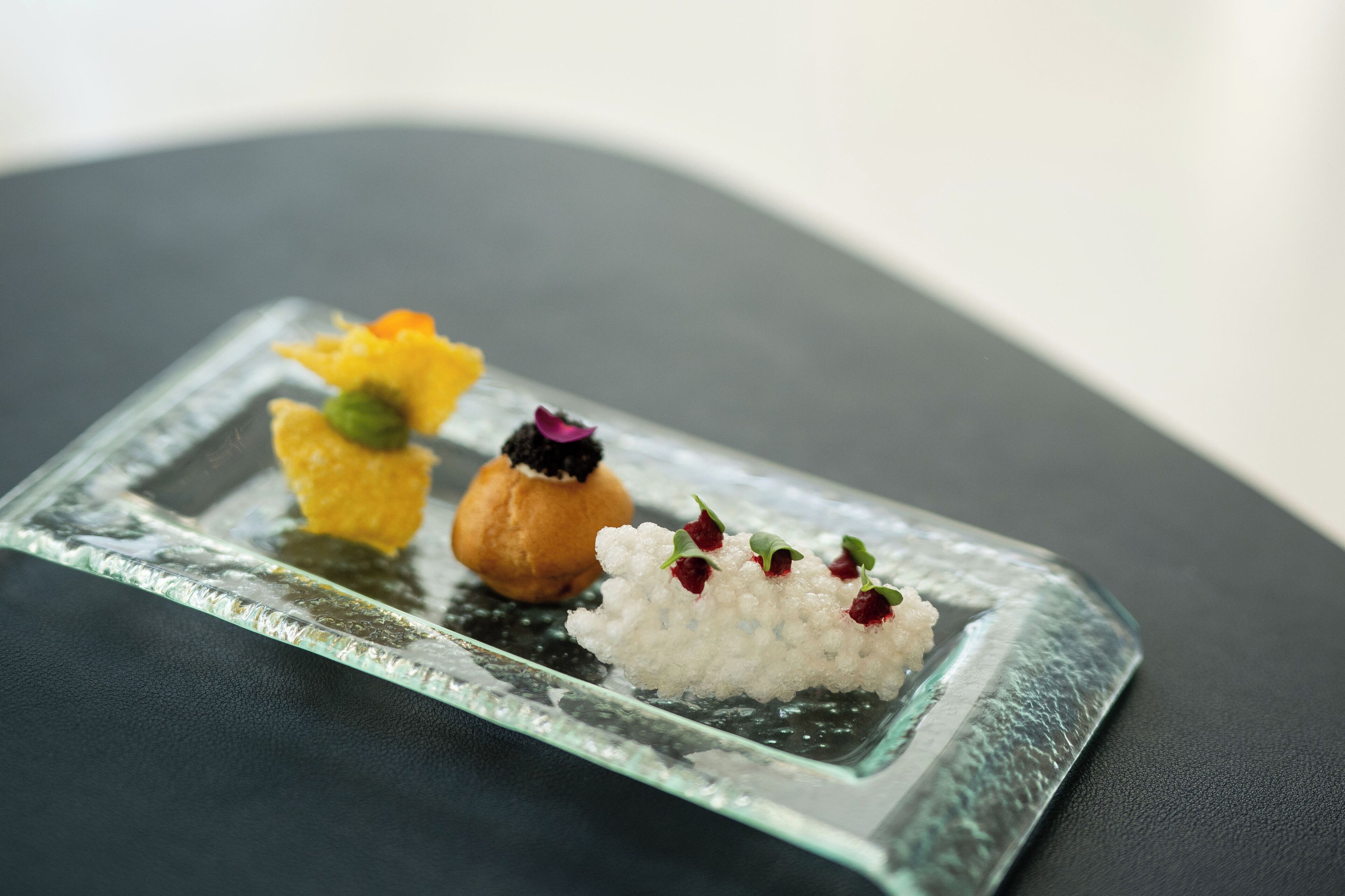 A glass dish with three different food items.