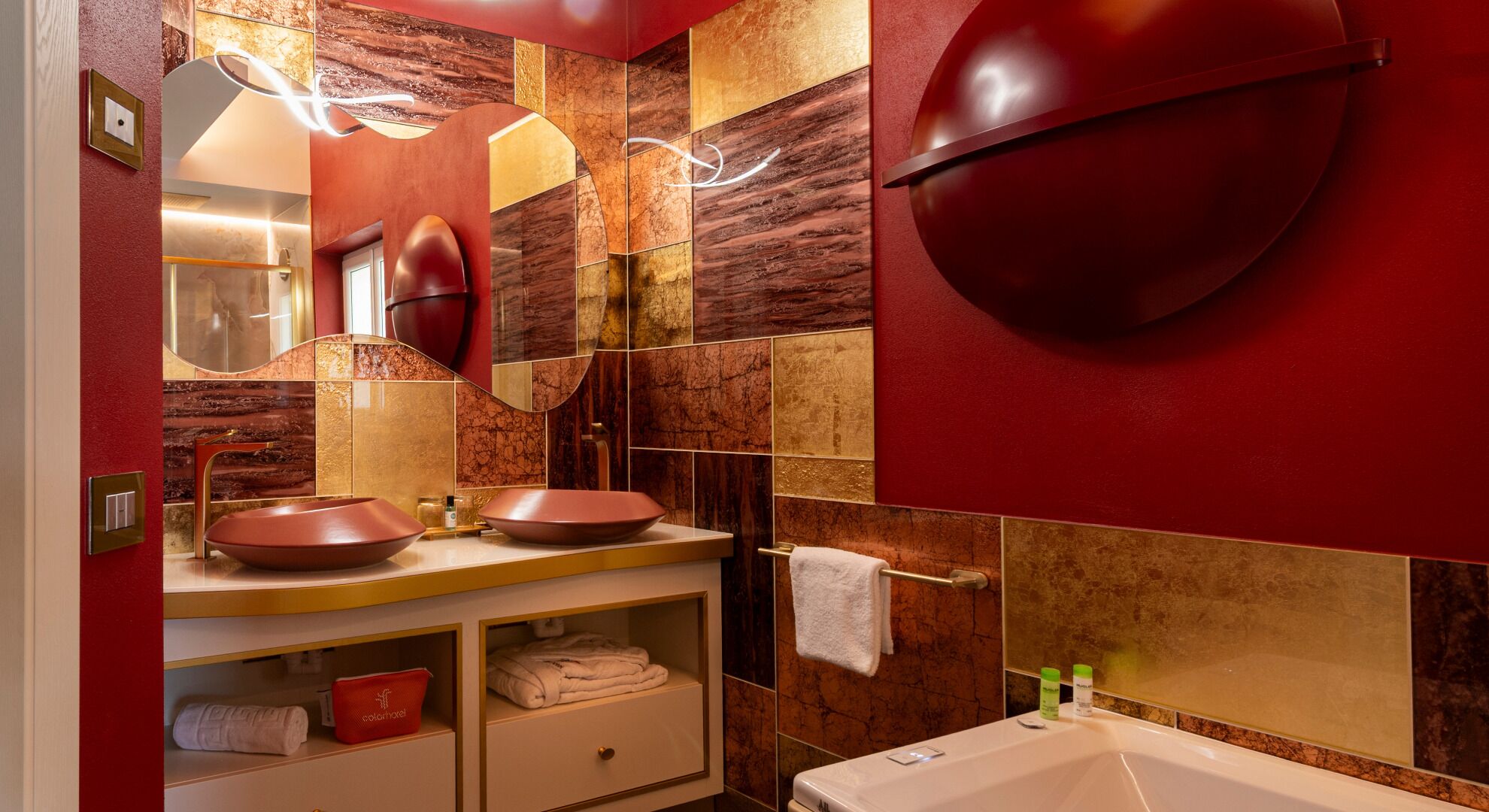 Un baño moderno con dos lavamanos, un espejo, toallero y una bañera.