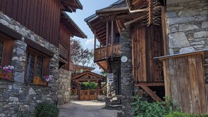 A rustic wooden building with stone walls, a wooden balcony, and a stone staircase. - Appart Duplex / La Plagne, Montchavin / 3 Chambres, 8 Pers / Pied des Pistes (La Plagne-Tarentaise)