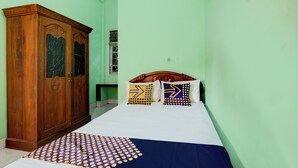 A bedroom with a bed, wooden wardrobe, and a window. - OYO Life 93265 Kos Cendana Seruni Raya (Mataram)