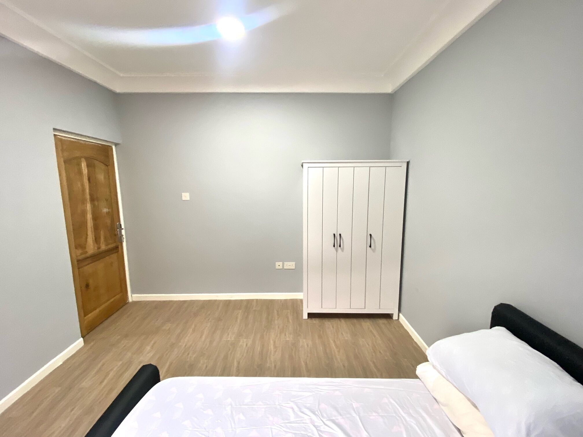 Un dormitorio con cama, armario y puerta.