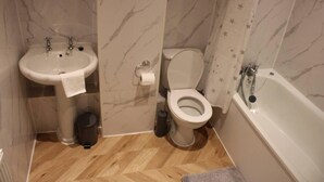 A bathroom with a sink, toilet, and bathtub. - Apartment - Sleeps 2 - Parking - Station Close (Dagenham)