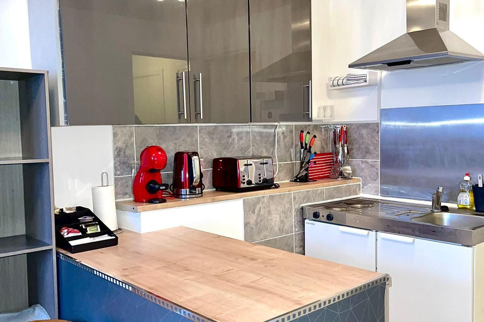 Uma cozinha moderna com bancada de madeira, eletrodomésticos de aço inoxidável e painel de azulejos.