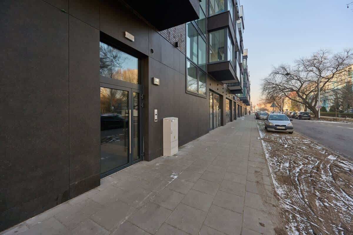 Moderni rakennus, jossa on suuret ikkunat ja jalkakäytävä.
