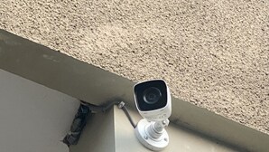 Een beveiligingscamera bevestigd aan de buitenmuur van een gebouw.
