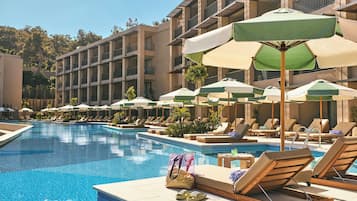 Een buitenzwembad, parasols bij het zwembad en ligstoelen