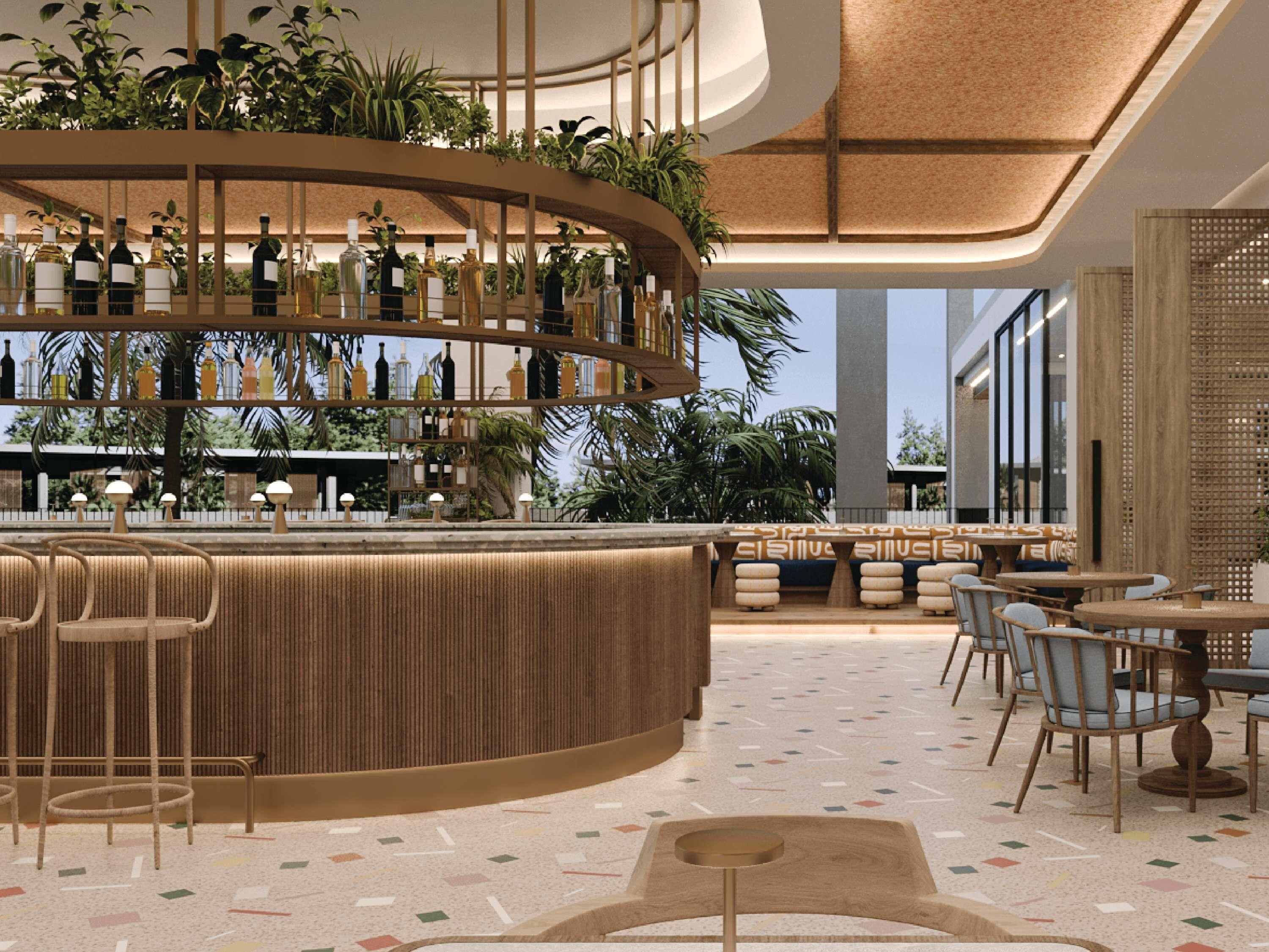 A modern bar area with a curved counter, multiple seating options, and a variety of bottles on shelves.