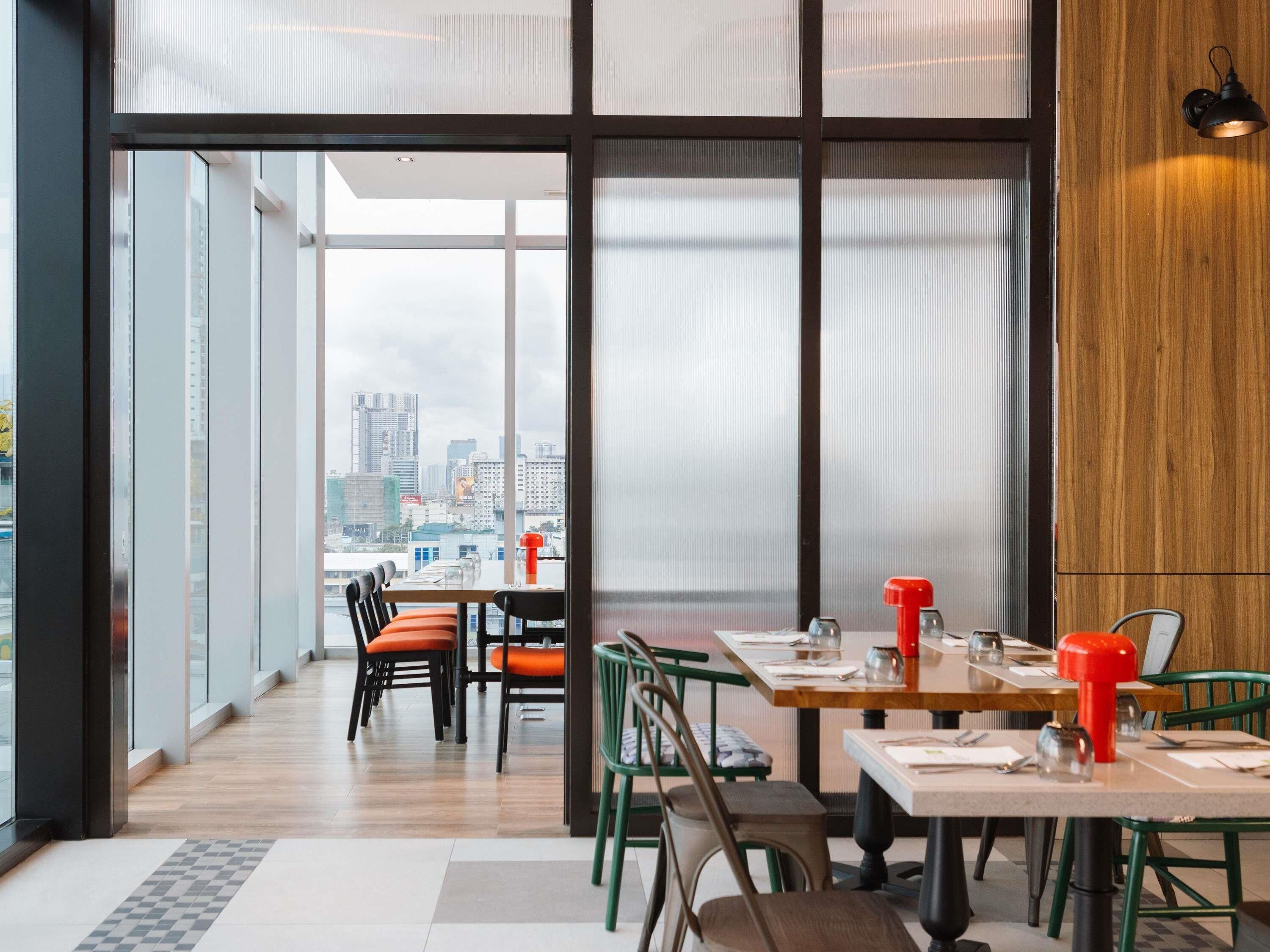 A modern dining area with large windows, wooden accents, and a city view.