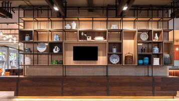 Un interior moderno con una unidad de madera que exhibe varios objetos decorativos y un televisor de pantalla plana.