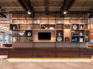 A modern interior with a wooden wall unit displaying various decorative items and a flat-screen TV.
