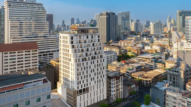Un hôtel de grande hauteur au design moderne, doté de nombreux balcons et d’une entrée imposante.