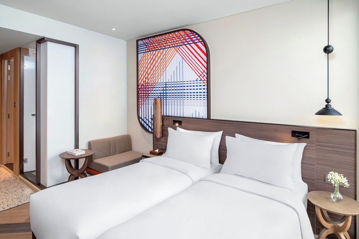 Une chambre d’hôtel avec un grand lit, un canapé, une petite table et un élément décoratif mural.