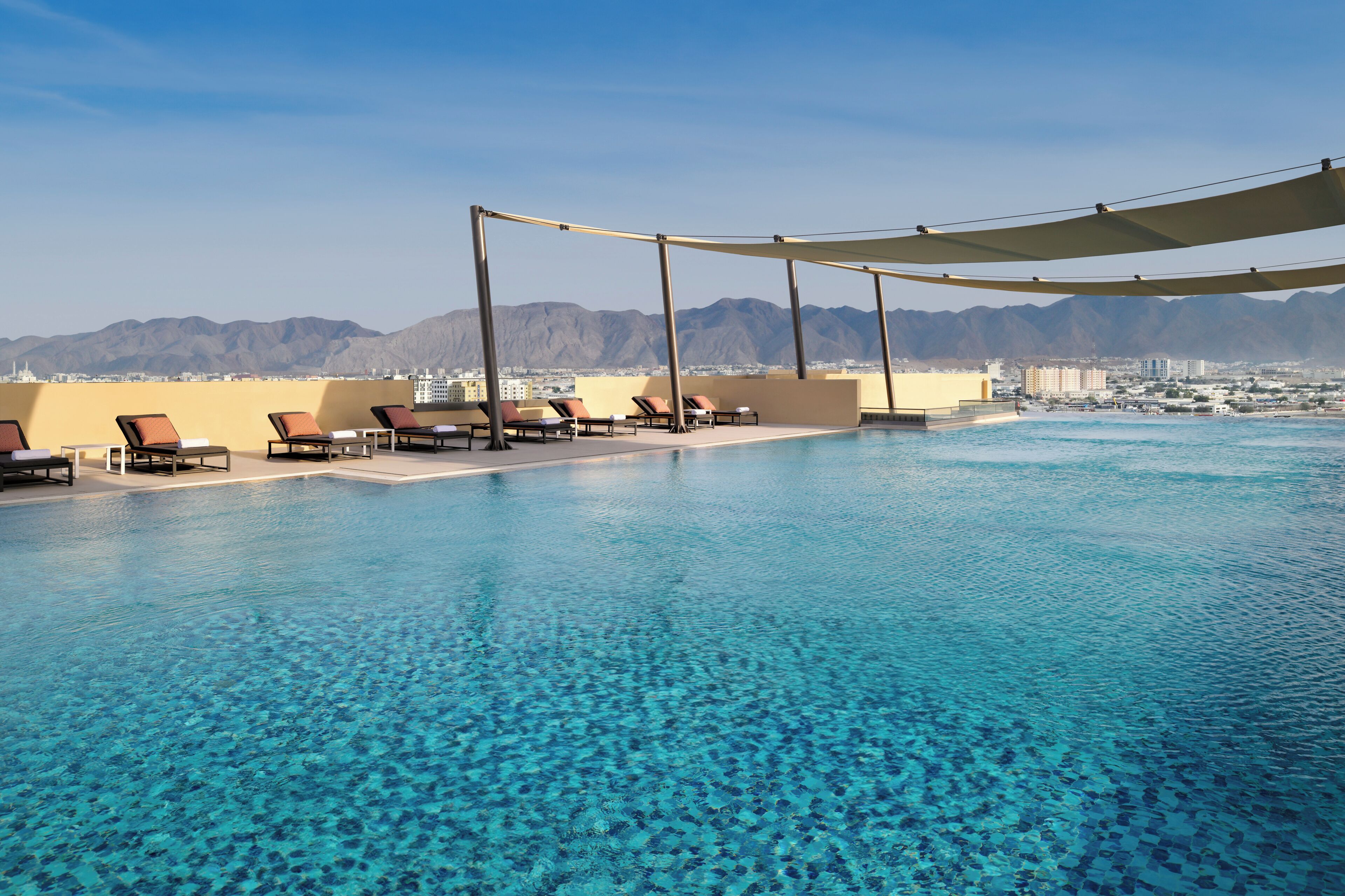 室外游泳池，池畔遮阳伞，日光浴躺椅