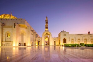 Une vaste cour ouverte, dominée par une mosquée imposante, reconnaissable à son haut minaret et à son dôme doré.