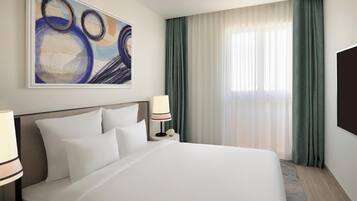 A hotel room with a large bed, a nightstand with a lamp, a wall-mounted TV, and a painting above the bed.