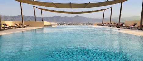 Een buitenzwembad, parasols voor strand/zwembad