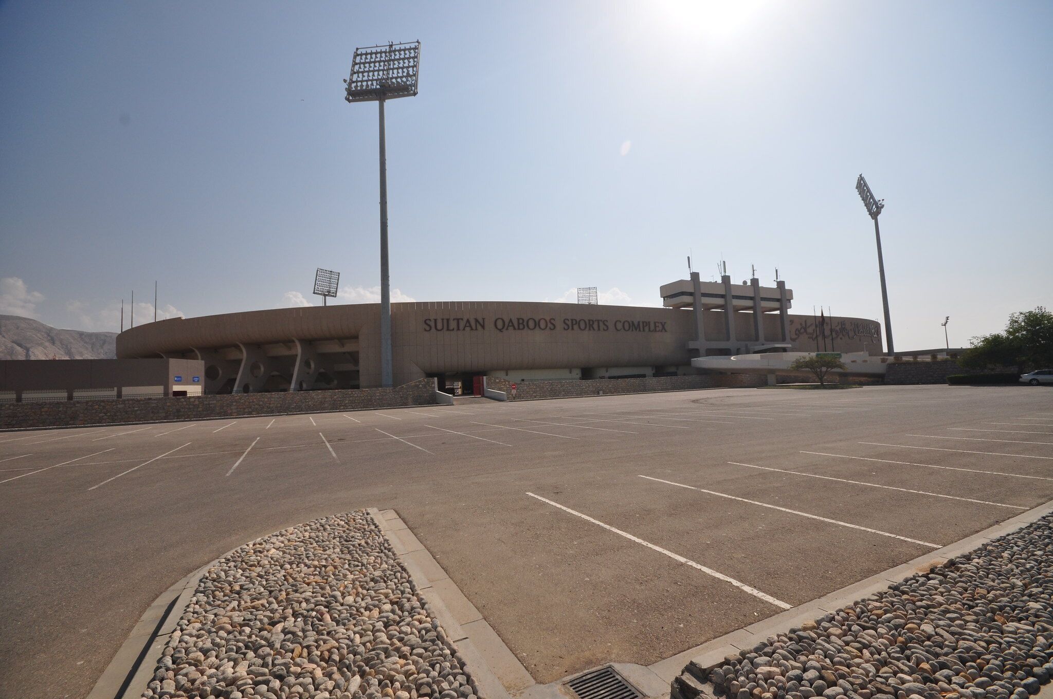 A large, modern sports complex with a curved facade and multiple levels.