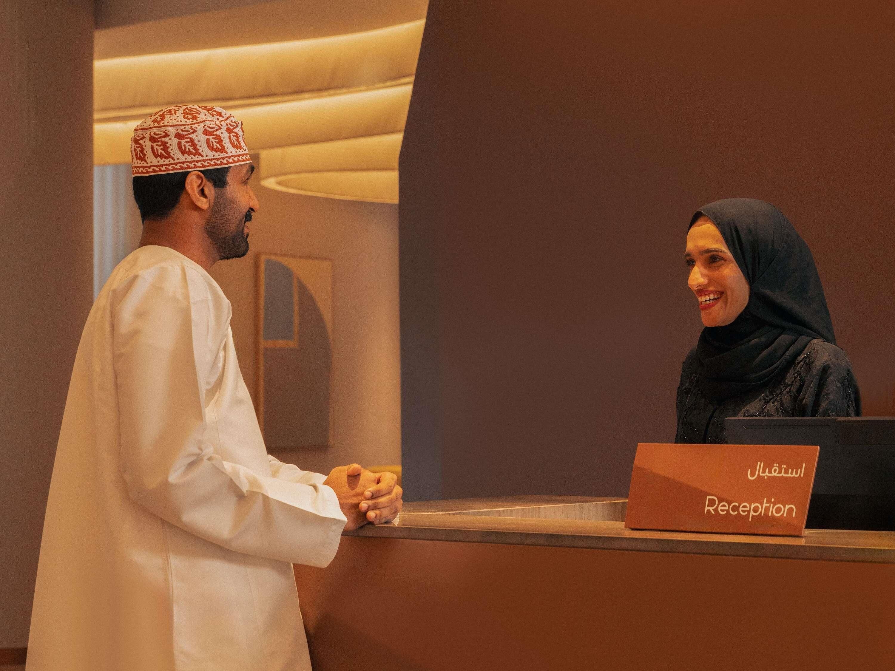 A reception desk with a sign that reads 'Reception' in Arabic.