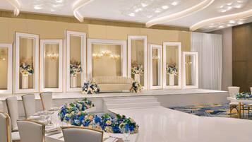 Ein formeller Speisesaal mit einem langen Tisch, mehreren Stühlen und dekorativen Blumenarrangements.