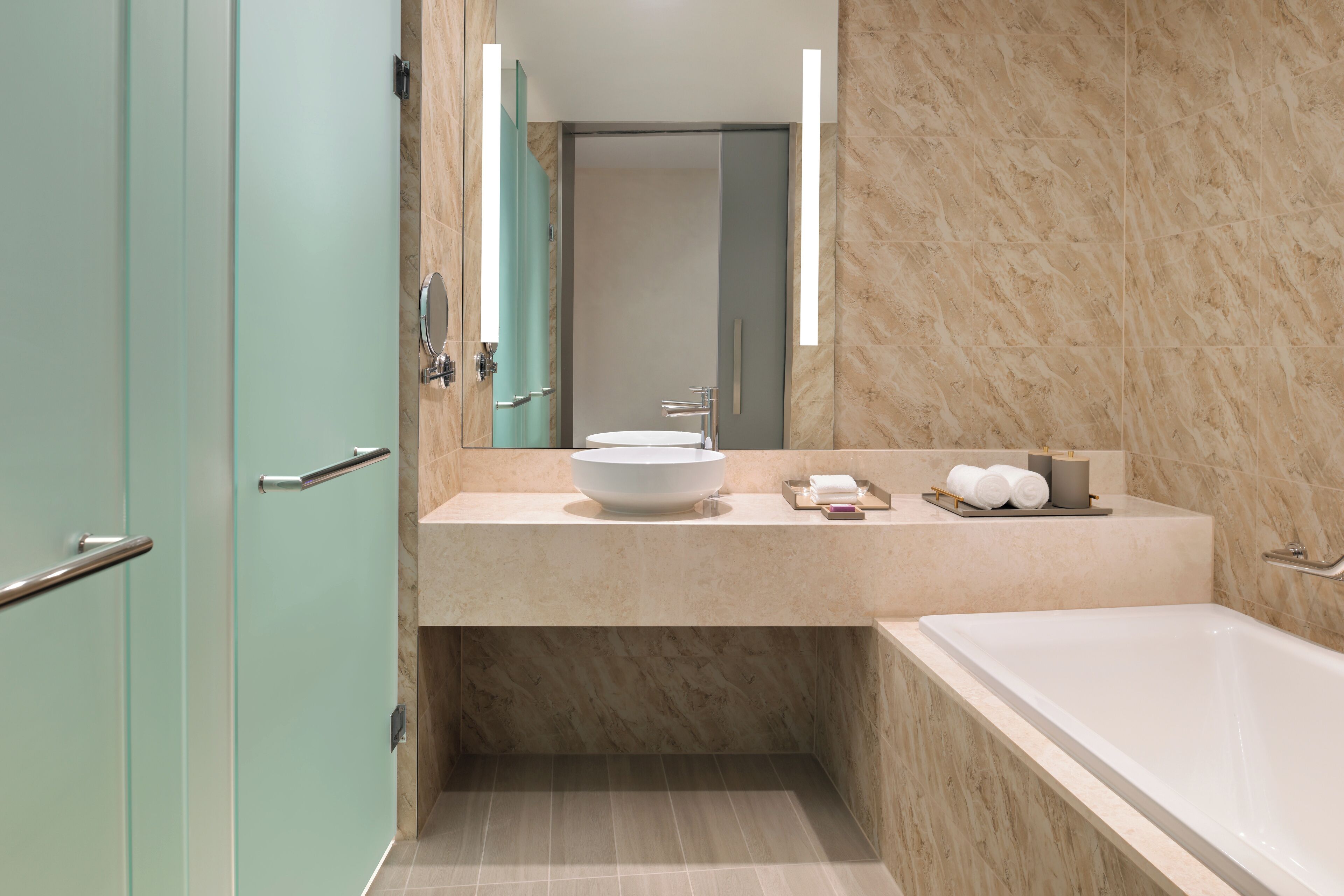 A modern bathroom with a large bathtub, a sink with a bowl, and a mirror above the sink.