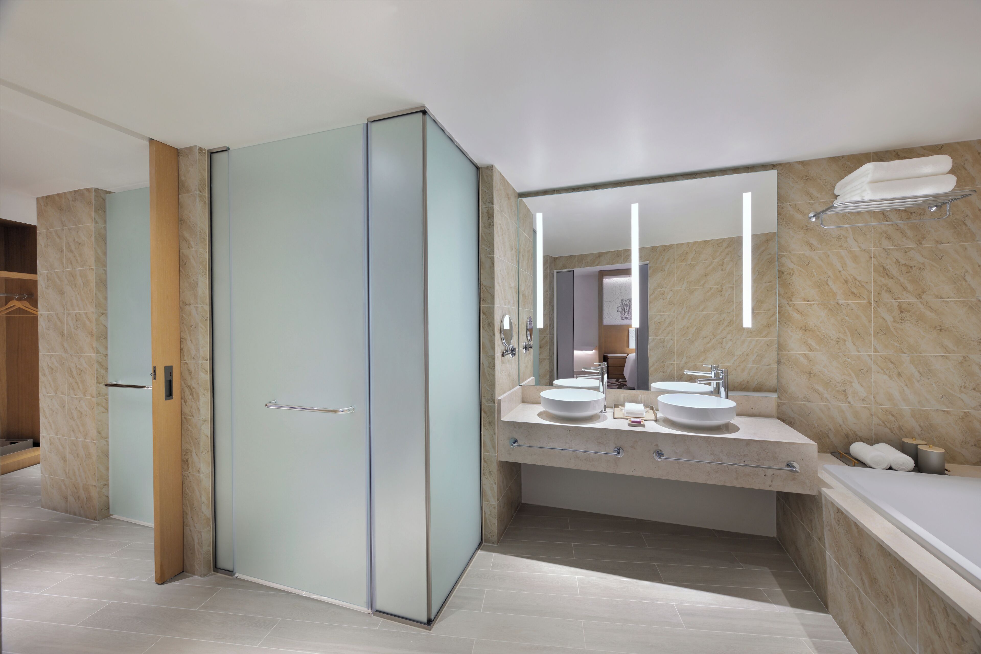Une salle de bain moderne avec une douche à parois de verre, un meuble-lavabo avec un évier et un miroir, et une baignoire.