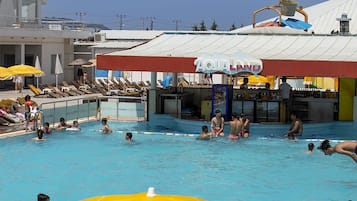 Un espace piscine avec un panneau indiquant « AQUA LAND » et un toboggan aquatique.